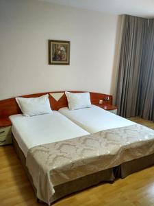 
a hotel room with two beds and two lamps at Philippopolis Hotel in Plovdiv
