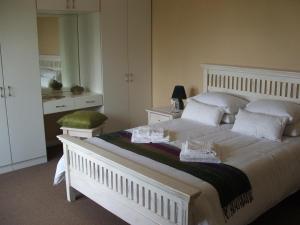 a bedroom with a large white bed with white pillows at Melody Guest House in Centurion