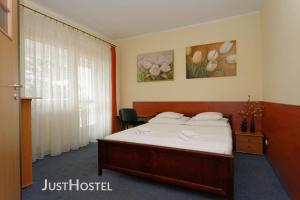 um quarto de hotel com uma cama e uma janela em Justhostel em Gdansk