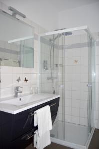 ein Bad mit einem Waschbecken und einer Glasdusche in der Unterkunft Pension zum Strell in Hollabrunn