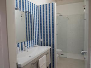 a bathroom with a sink and a toilet and blue tiles at La Casa Di Pina in Sampieri +15 photos