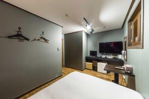 a bedroom with a bed and a desk and a tv at 8MOTEL in Seoul