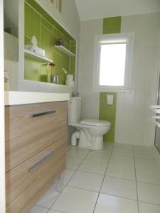uma casa de banho branca com um WC e uma janela em Maisonnette rénovée em Lacrabe
