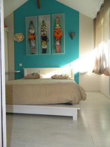 um quarto com uma cama com quatro fotografias de cones de gelado em Maisonnette rénovée em Lacrabe