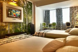 a hotel room with two beds and a painting on the wall at Continental Forum Arad in Arad