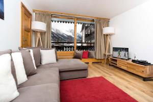 a living room with a couch and a television at Les Balcons du Savoy 104 appt - Chamonix All Year in Chamonix