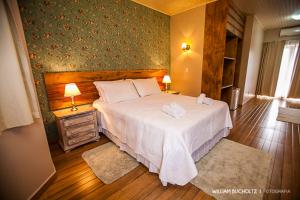 ein Schlafzimmer mit einem Bett mit zwei Handtüchern darauf in der Unterkunft Pousada Pedra Preta in Urubici