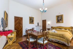 een slaapkamer met een bed en een tafel en stoelen bij Venice Dose Guesthouse in Venetië