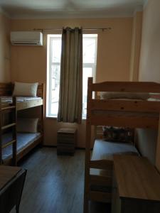 a room with several bunk beds and a window at Hostel Ginger House in Plovdiv