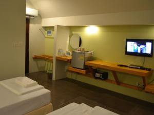 a hotel room with a television and a bed at Phuket Campground in Mai Khao Beach