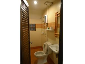 a bathroom with a toilet and a sink at Phuket Campground in Mai Khao Beach