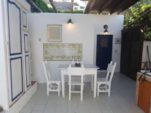een witte tafel en stoelen op een patio bij Con i piedi nell'acqua in Stromboli