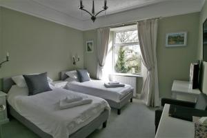 um quarto com 2 camas e uma janela em Ferndale Lodge em Torquay