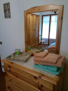 een spiegel op een houten dressoir met handdoeken bij Il Giardino di Marina in Santa Maria Maggiore +1 foto