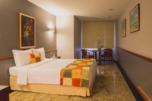 里约热内卢Hotel Atlantico Star的一间带床和桌子的酒店房间