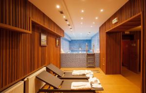 ein Zimmer mit Tisch und Stühlen und einer Badewanne in der Unterkunft Hotel Askania in Prag