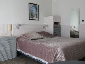 a bedroom with a large bed and a fireplace at Le Parasol in Ars-en-Ré