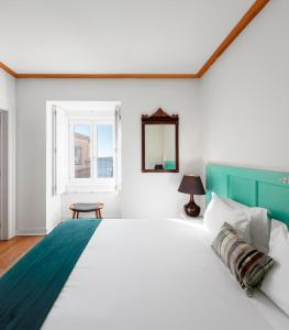 里斯本的住宿－帕拉西奧賈梅士- 里斯本服務式公寓，一间卧室设有一张大床和一个窗户。