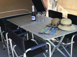 a table with a bottle of wine and two hats at Camping Villasol in Benidorm