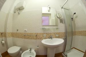 bagno con lavandino, servizi igienici e specchio di SunMoon a Reggio di Calabria
