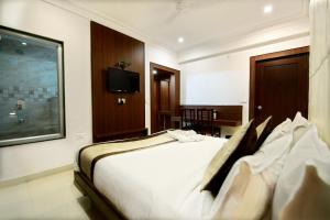 a hotel room with a bed and a television at Hotel Sunflower Udaipur in Udaipur +23 photos