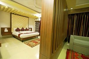 a bedroom with a bed and a couch in a room at Hotel Sunflower Udaipur in Udaipur