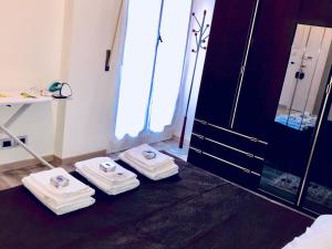 ein Badezimmer mit drei Handtüchern auf dem Boden neben einer Tür in der Unterkunft Ylli home Sanremo in Sanremo