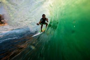 a man riding a wave on a surfboard in the ocean at Bingin Inn in Uluwatu