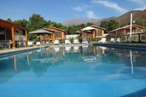 una piscina en un complejo con montañas en el fondo en Cabañas Antilhue en Olmué