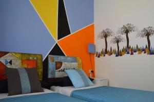 a bedroom with two beds and a colorful wall at Leonardo's Rooms in Pontassieve