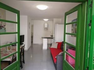 カレタ・デ・フステにあるPuerta del solのリビングルーム(緑のドア、赤いソファ付)