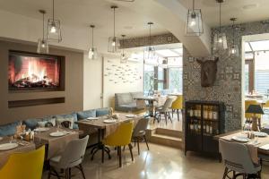 a restaurant with tables and chairs and a fireplace at ZENTRUM Hotel in Chişinău