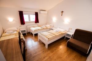 Habitación con 3 camas y una cruz en la pared. en Rooms Kenedy, en Međugorje