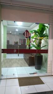 a glass door with a potted plant in a room at Hotel Letiva Arco in Sobral