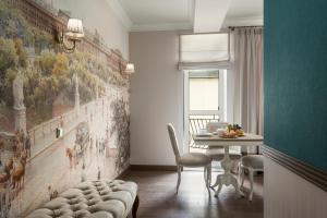 uma sala de jantar com uma mesa e um quadro na parede em ZENTRUM Hotel em Chisinau