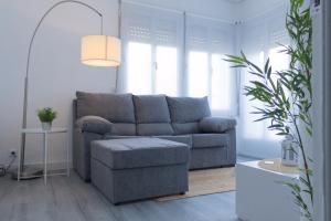 ein Wohnzimmer mit einem grauen Sofa und einem Tisch in der Unterkunft Apartamento del Sueño in Logroño