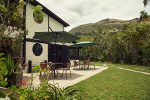a house with a patio with chairs and umbrellas at Estancia De La Campiña in Nono