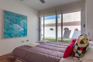 a bedroom with two beds and a large window at El Atico del MARQUES free parking by Cadiz4Rentals in Cádiz