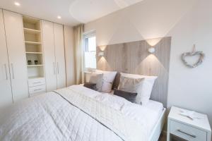 シャルボイツにある301 Seaside viewのベッドルーム(白いベッド1台、ハートミラー付)