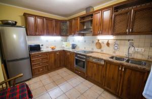 a kitchen with wooden cabinets and a stainless steel refrigerator at Seventh Heaven in Mykulychyn