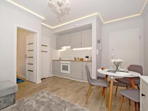 a kitchen and dining room with a table and chairs at Apartament Starogdański 7 in Gdańsk