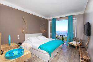 een slaapkamer met een groot bed en een groot raam bij Hotel Scandola in Piana