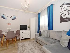 a living room with a gray couch and a table at Apartament Starogdański 7 in Gdańsk