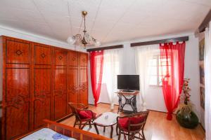 um quarto com cortinas vermelhas, uma mesa e cadeiras em Apartment Johanna em Opatija