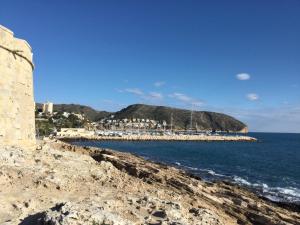 widok na ocean i skalistą plażę w obiekcie Villa San Antonio w mieście Moraira