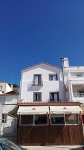 a white building with an awning in front of it at Casa do Rio in Alcácer do Sal