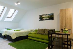 ein Wohnzimmer mit einem Bett und einem grünen Sofa in der Unterkunft Apartmány pre Vás in Levice