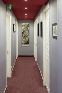 a hallway in an office building with a red carpet at Hôtel Le Home Saint Louis in Versailles