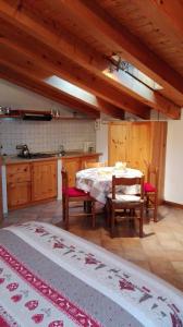 kuchnia ze stołem i krzesłami w pokoju w obiekcie Sweet Home Casa Vacanze "La Mansarda" w mieście Rovetta +8 zdjęć