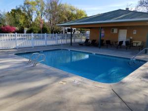 a swimming pool in a yard with a white fence at Gridley Inn & RV Park in Gridley